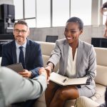 People sitting in office shaking hands at the start of a mediation