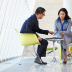 Lawyer man and attorney woman with tablet having discussion