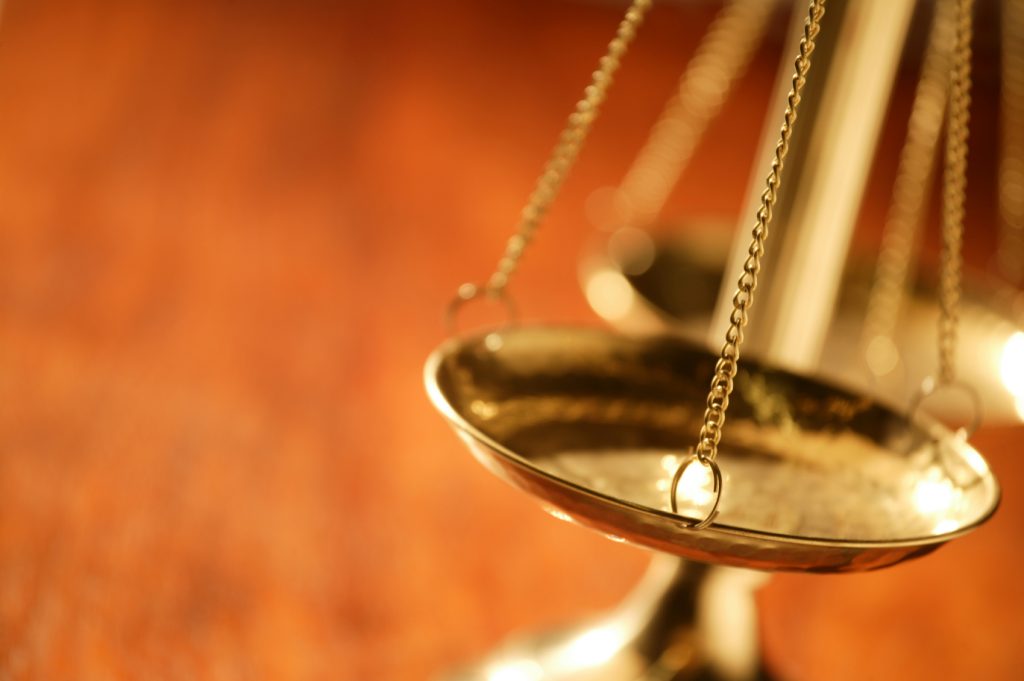 Wood desk with Scales of Justice on it.