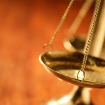 Wood desk with Scales of Justice on it.
