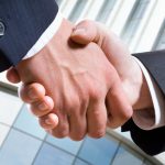 Closeup picture of business people shaking hands, making an agreement.